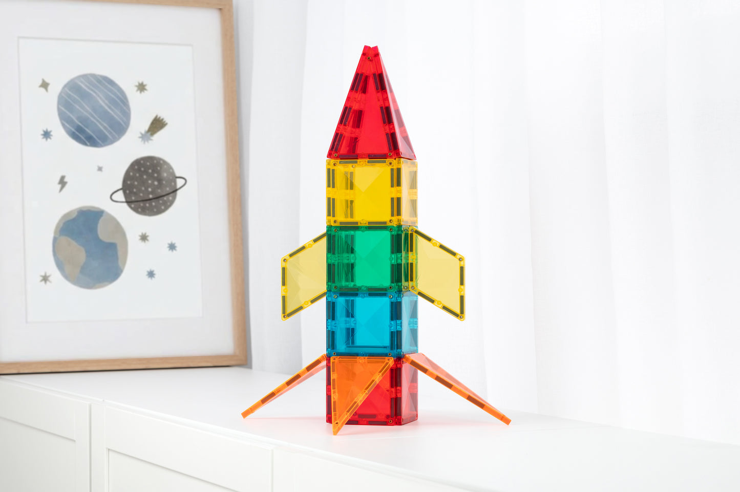 Magnetisch speelgoed Connetix raket op kinderkamer kastje met ruimte poster, kleurrijke tegels