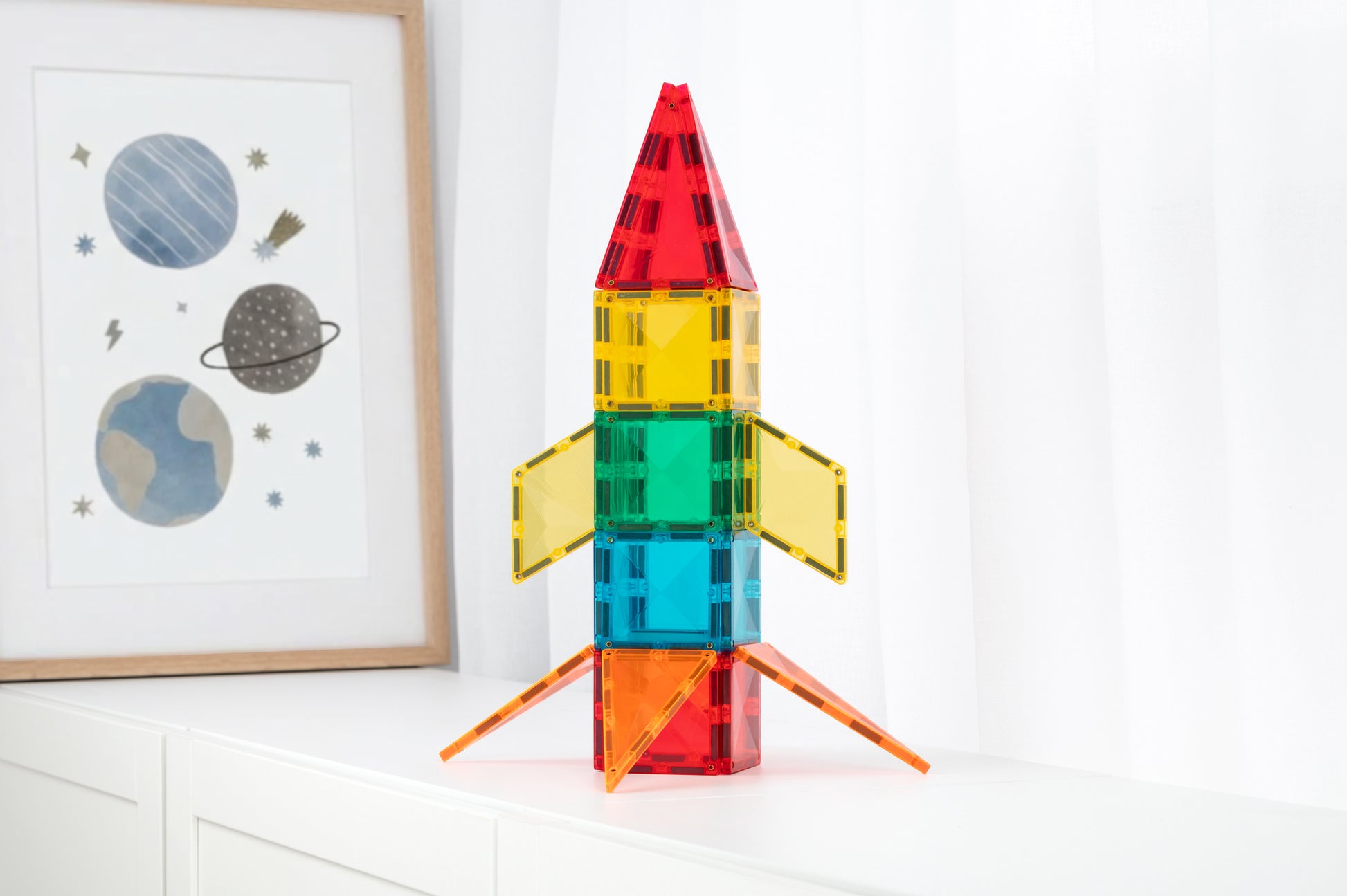 Magnetisch speelgoed Connetix raket op kinderkamer kastje met ruimte poster, kleurrijke tegels