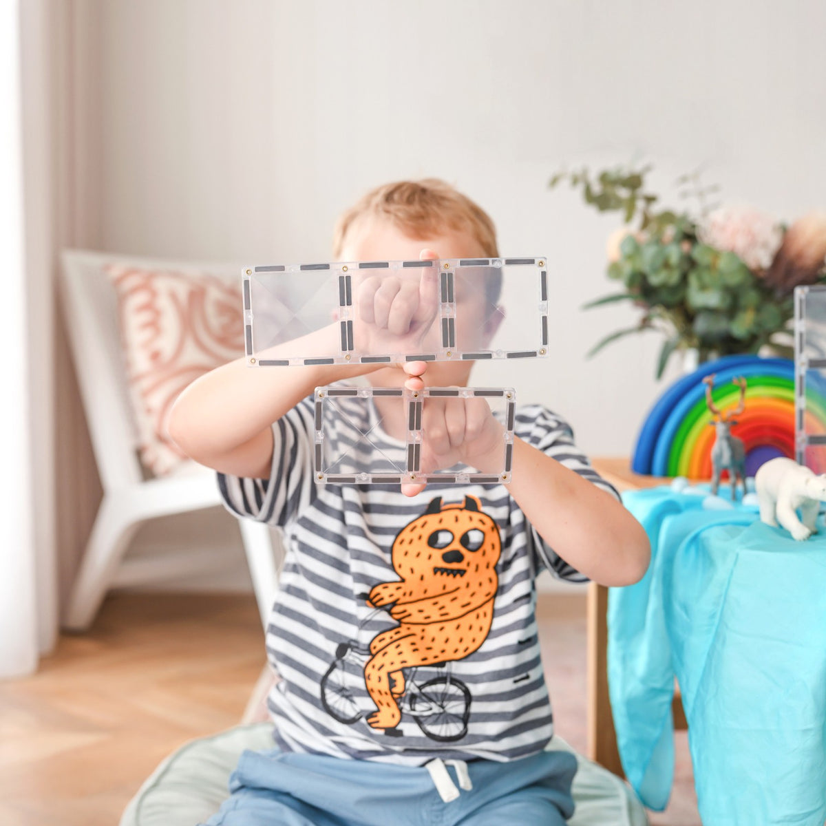 Kind speelt met Connetix Rectangle transparante magneet tegels en bouwt constructies creatief speelgoed