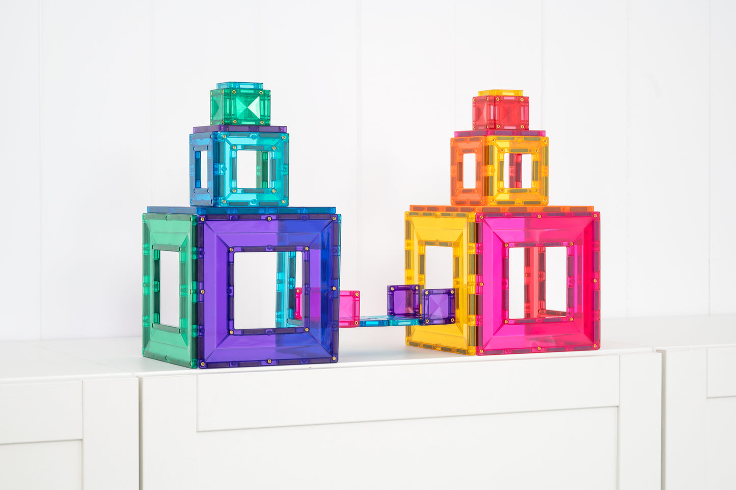 Twee kleurrijke torens gebouwd met Connetix Bright Portal Pack 48pc speelgoed met magneten op kast