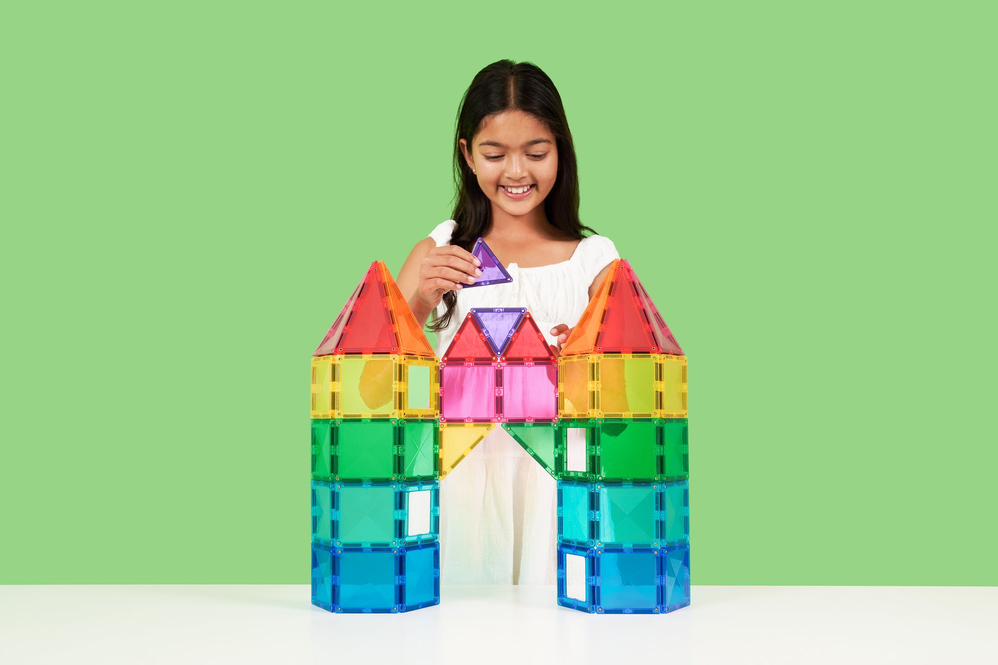 Kind speelt met Connetix Bright Creative Pack 104 magnetische tegels kasteel groene achtergrond