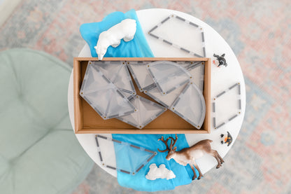Connetix tiles bovenaanzicht clear tegels in houten doos met speelfiguren en winterdecoratie