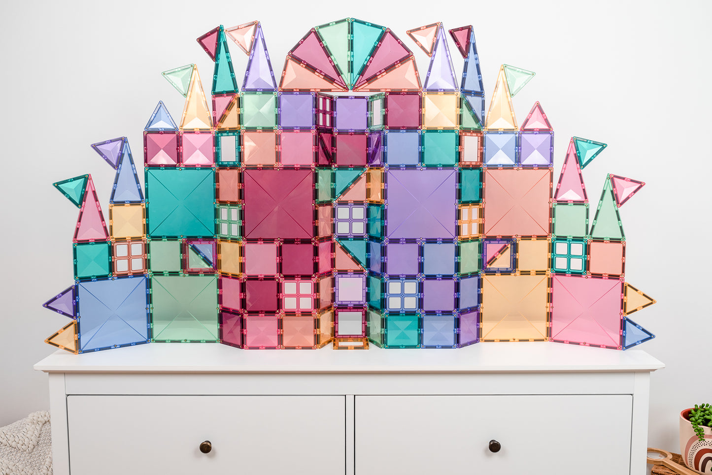 Connetix magnetische tegels kasteel gebouwd in pastelkleuren roze blauw groen paars op wit dressoir