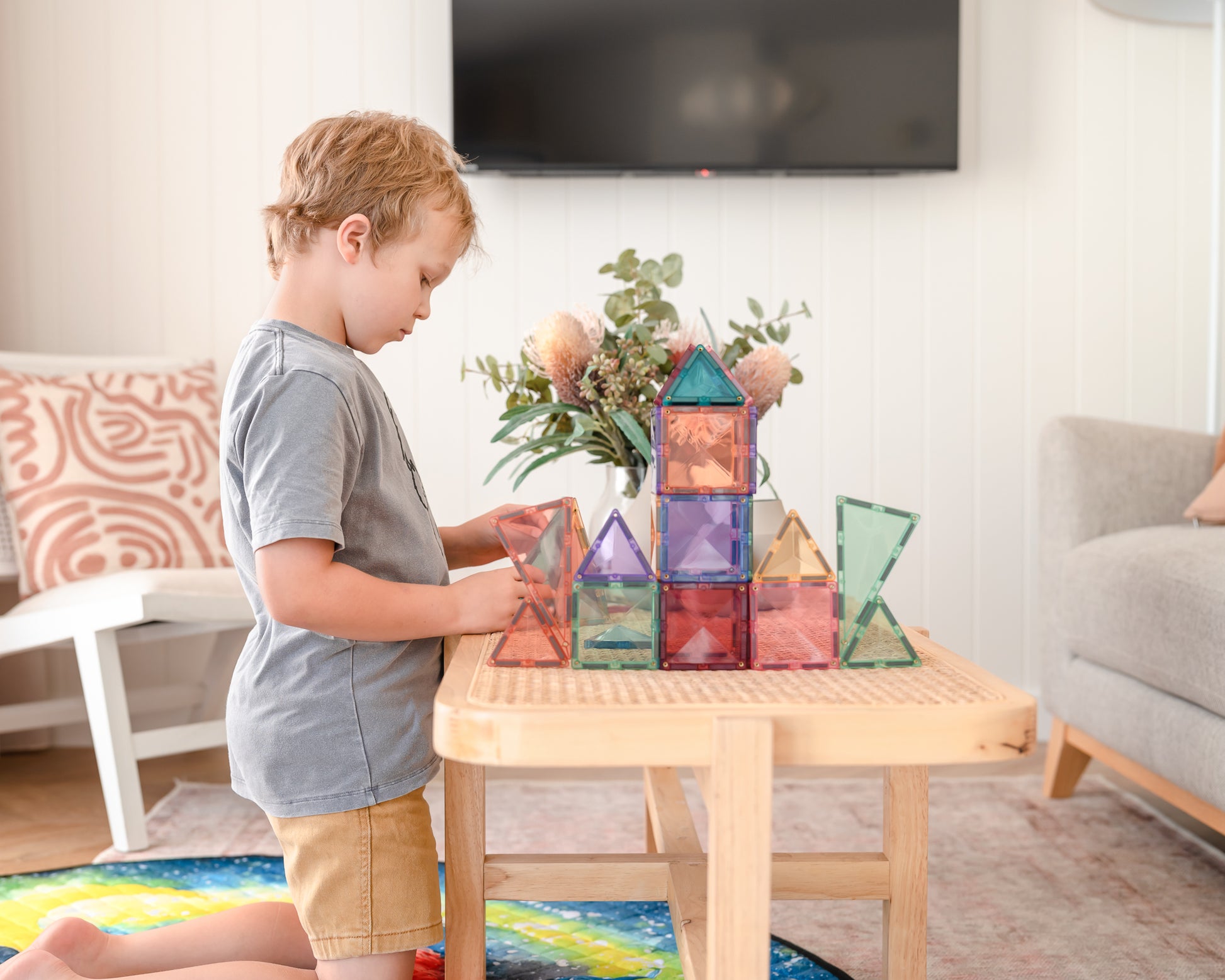 Jongen bouwt toren met Connetix Pastel Starter Pack 64pc magneten speelgoed aan salontafel in woonkamer