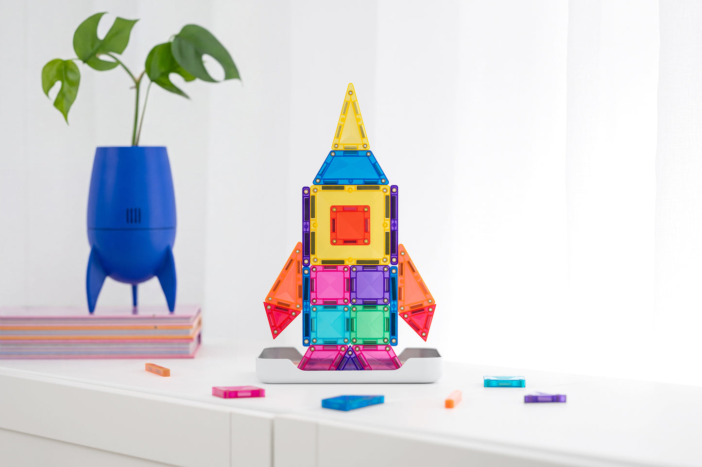 Connetix travel mini pack raket gebouwd met kleurrijke magnetische tegels op witte plank met plant