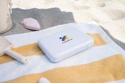 Connetix travel mini pack gesloten witte koffer met logo op gestreepte strandhanddoek