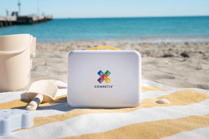 Connetix travel mini pack witte koffer met geel handvat op handdoek strand als vakantie speelgoed