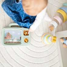 Detail foto bovenaanzicht baby met sensorisch speelgoed, vintage tv-speelset en stapeltoren