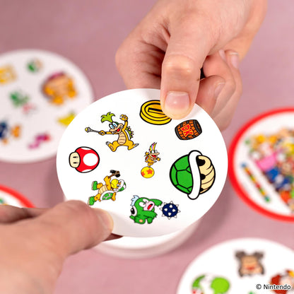 Close-up van Dobble Super Mario kaart met Donkey Kong ton, Koopa schild en munt, educatief zoekspel en motorisch spel voor kinderen.