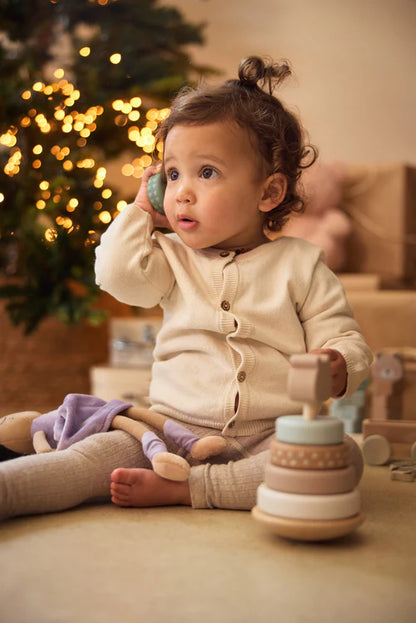 Baby speelt op de grond met houten tuimelstapelaar van Jollein, een educatief Montessori speelgoed voor jonge kinderen.