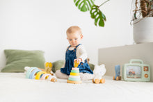 Baby met educatief speelgoed stapeltoren en houten figuren, montessori babykamer met speelkleed