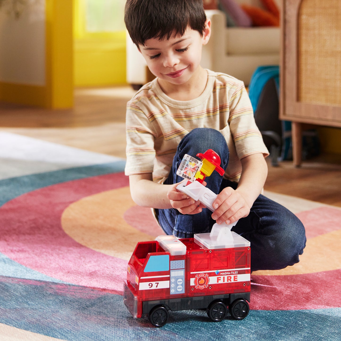 Magnetic magna tiles Fire Station jongen speelt met magnetische brandweerwagen en brandweerman figuur thuis