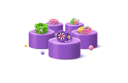 Hey Clay Bijou Alien Rings op paarse podia: 5 grappige klei-ringen in groen, roze en paars.