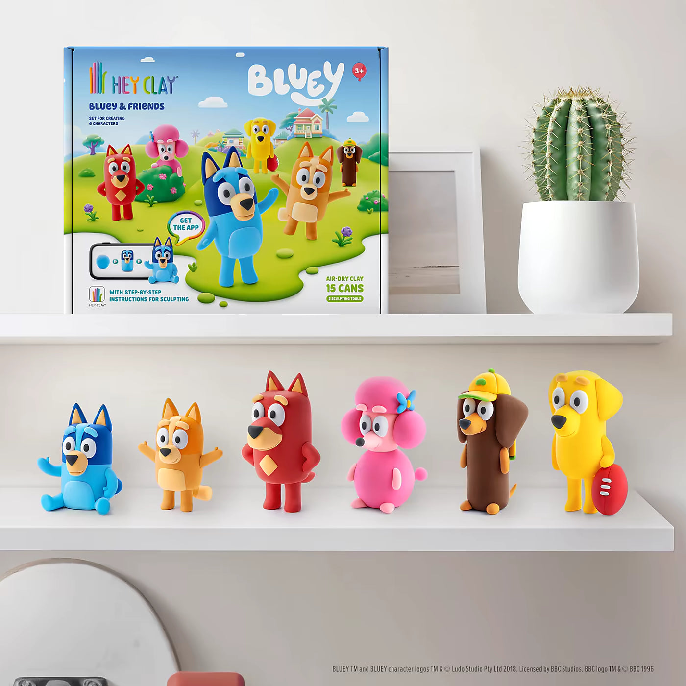 Zelfgemaakte figuren uit Hey Clay Bluey & Friends boetseerklei set, zoals Bluey, Bingo en Mackenzie op een plank.