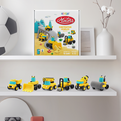 Hey Clay Construction Vehicles verpakking op plank met zes gemaakte boetseerklei voertuigen eronder