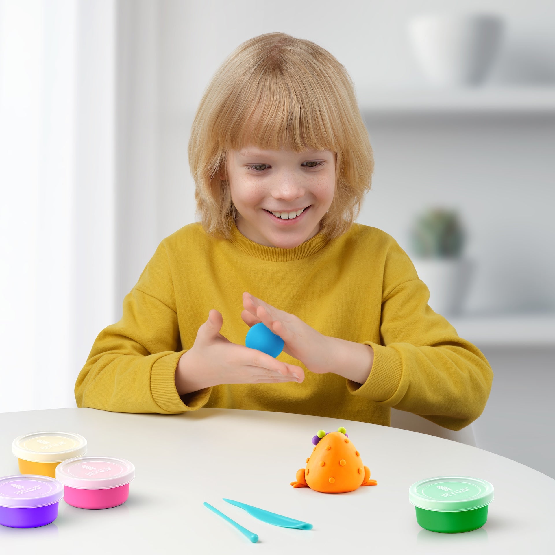 Hey Clay kind kleien met oranje kikker en potjes boetseerklei, creatief speelgoed moment