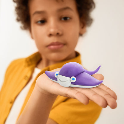 Hey Clay paarse pijlstaartrog detailfoto: kind toont zelfgemaakte oceaandier van kleurrijke boetseerklei