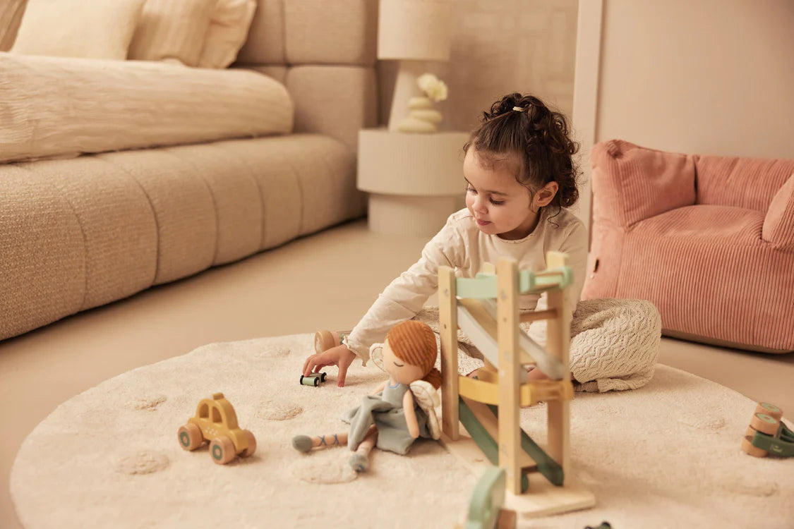 Peuter speelt op rond kleed met houten auto van Jollein, een veilige en leuke keuze voor baby speelgoed of cadeau.