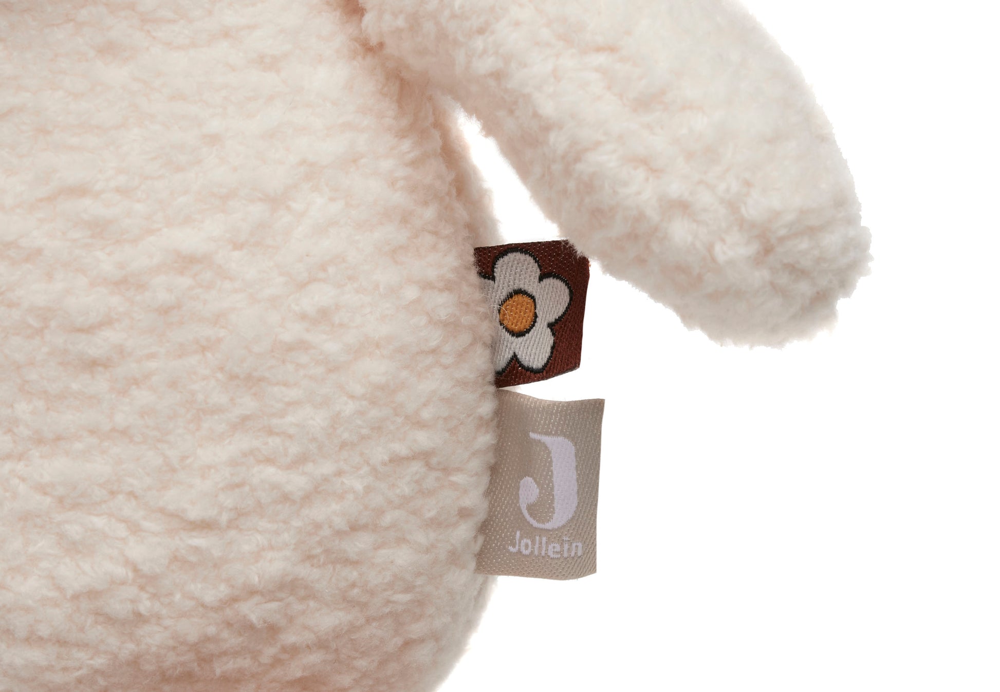 Detailfoto Jollein activiteiten knuffel met bruin bloementje label en beige merklabel, sensorisch speelgoed