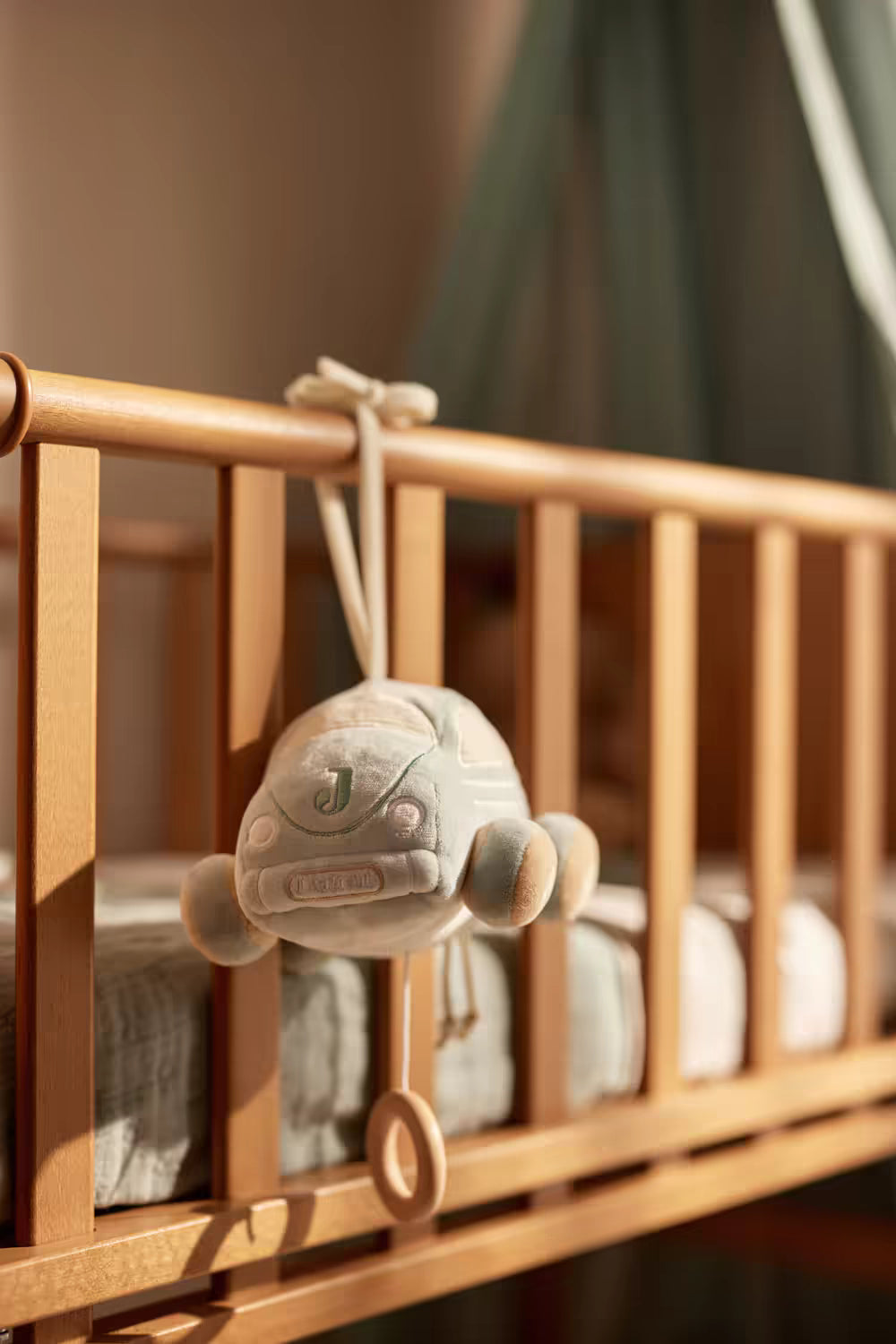 Zacht Jollein muziekdoosje in auto vorm, bevestigd aan wieg met trekkoord en houten ring, leuk kraamcadeau.