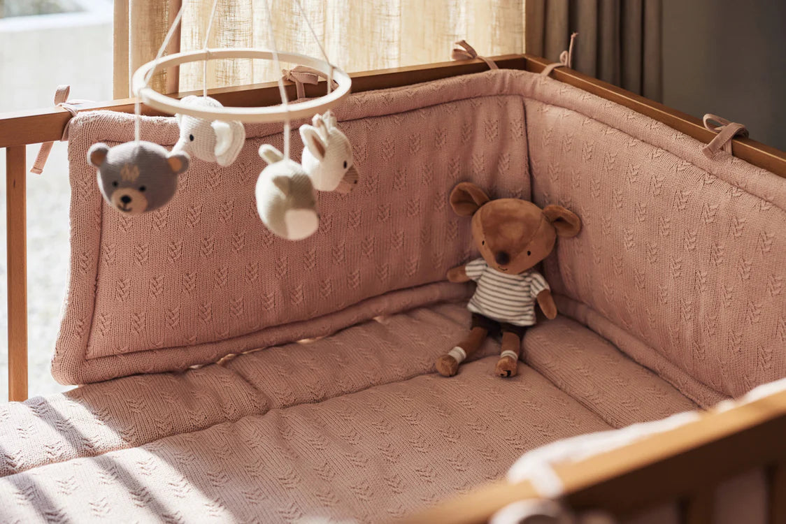 De Jollein Baby Mobiel Animals boven een zachte boxopstelling met teddybeer, sfeervol baby speelgoed in natuurlijke setting.