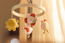Jollein baby mobiel Pretty Picnic sfeerbeeld: pluche bloem karakter centraal aan houten ring, baby cadeau idee.