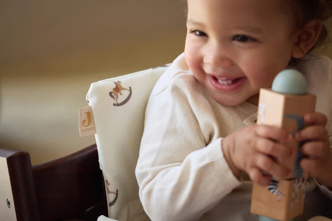 Blije baby speelt met houten Jollein draaipuzzel, leert grijpen en draaien met dit vrolijke peuterspeelgoed in hout.