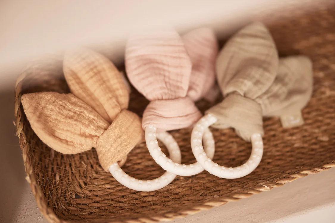 Set van drie Jollein Bijtring Siliconen Bunny Ears in Moonstone, roze en groen in mandje als box speelgoed.