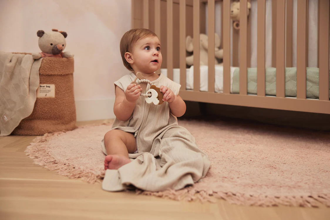 Peuter speelt op vloerkleed met Jollein Bijtring Siliconen Teddy Bear, praktisch baby speelgoed voor in huis.