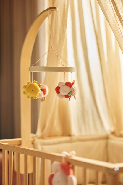 Jollein boxmobiel Pretty Picnic sfeerbeeld boven houten wieg: pluche zon en bloem hangen aan houten ring.