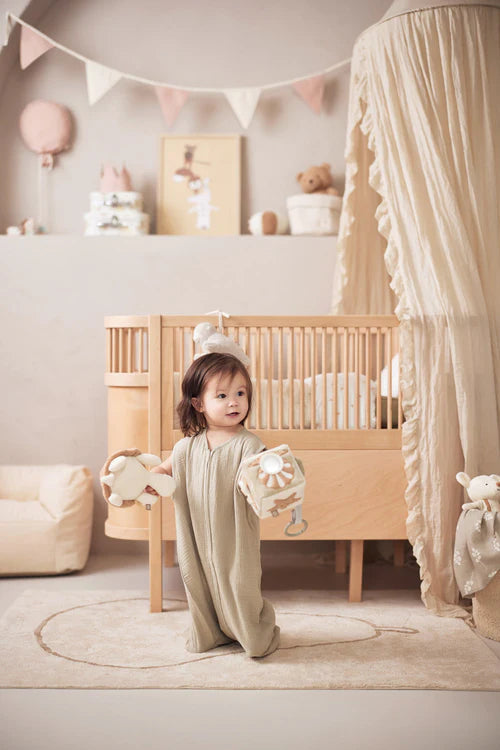 Peuter speelt met de Jollein Deepsea activiteitenkubus in een natuurlijke babykamer, ideaal als educatief speelgoed.