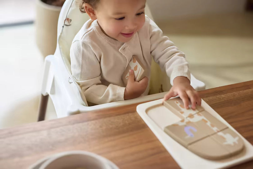 Peuter speelt zelfstandig met houten Montessori puzzel aan tafel, stimuleert concentratie en fijne motoriek.
