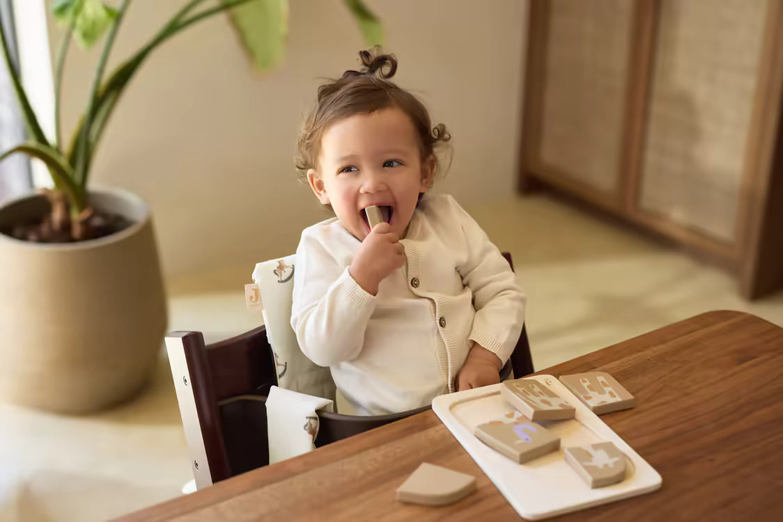 Peuter speelt met Jollein Houten puzzel Giraffe aan tafel, duurzaam houten speelgoed voor peuters en baby’s.