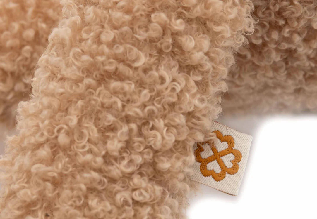 Detailfoto van het Jollein-label aan de biscuitkleurige knuffel bunny, toont textuur en afwerking van het pluche.