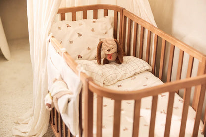 Jollein knuffel Diego in houten ledikant tussen zachte lakens, perfect als baby speelgoed of kraamcadeau.