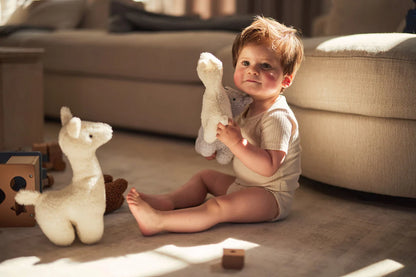 Peuter speelt met Jollein knuffel lama in off-white, ideaal babycadeau en speelgoed voor jonge kinderen.