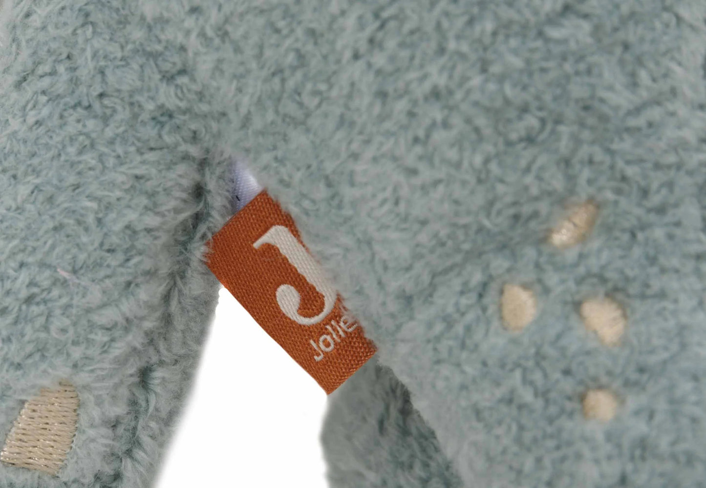 Detail van zachtblauwe Jollein Knuffel Roarsome met roestkleurig label, perfect als kraamcadeau voor baby’s.