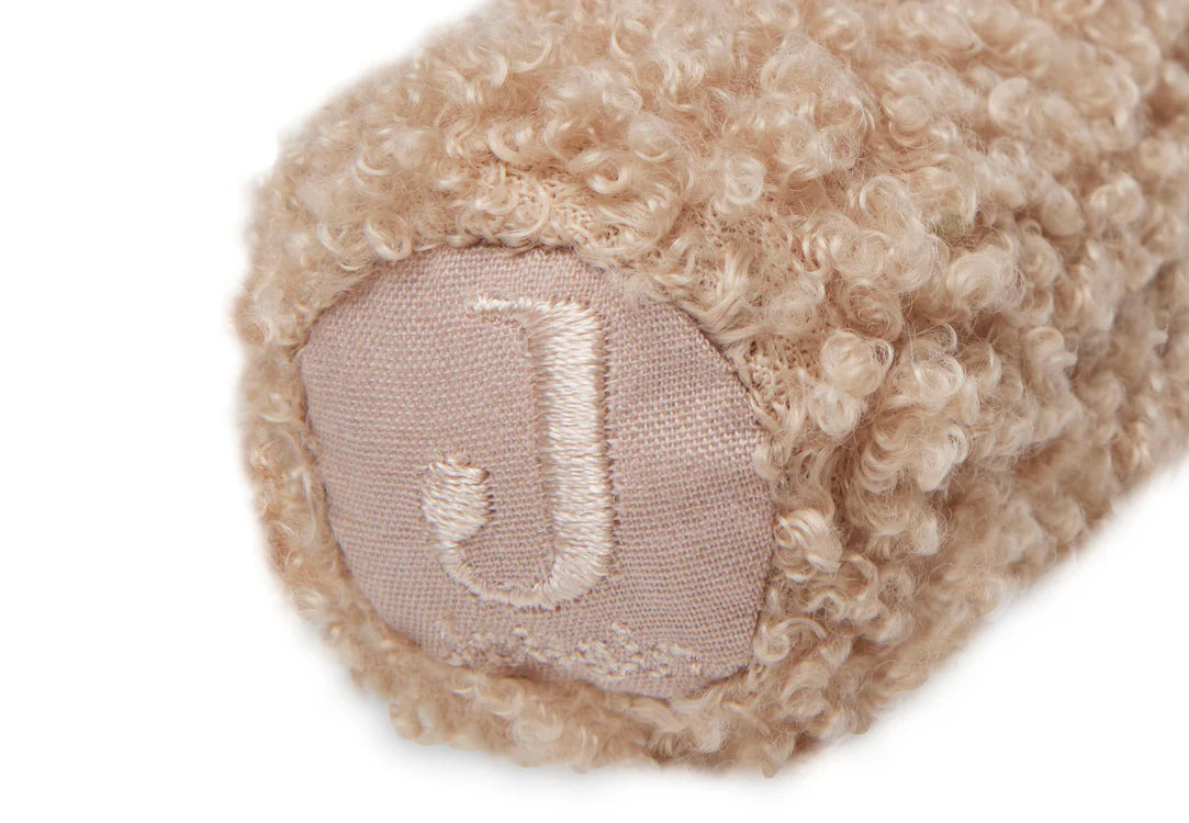Detail van Jollein rammelaar Biscuit met geborduurde J op roze-beige teddy stof, zacht baby speelgoed en sensorisch speelgoed.