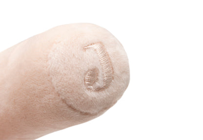 Detailfoto Jollein rammelaar Pretty Picnic slak op vinger, zacht pluche materiaal baby speelgoed close-up