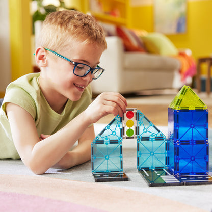 Jongen bouwt met magnetic magna tiles Police Station met verkeerslichten en blauwe magneet tegels