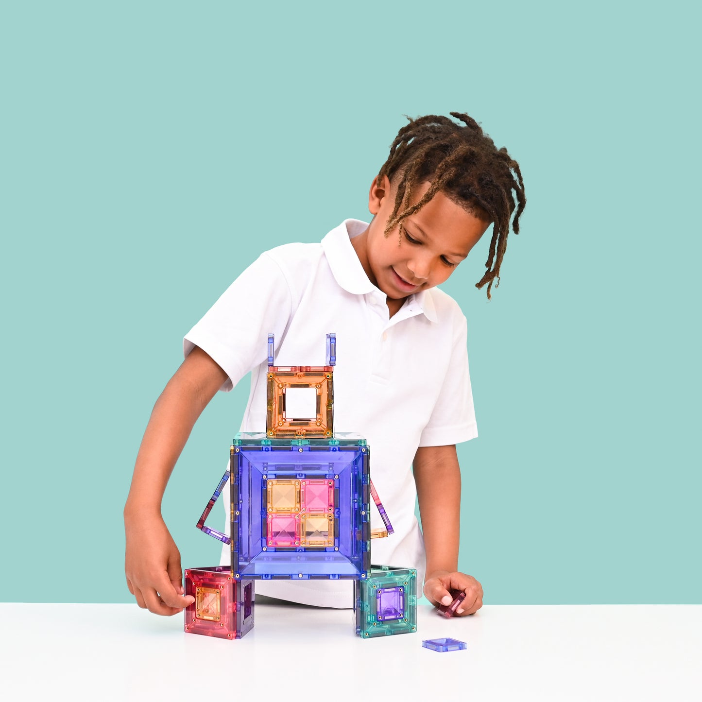Jongen speelt met Connetix Pastel Portal Pack 48pc magneten speelgoed op mintgroene studio achtergrond