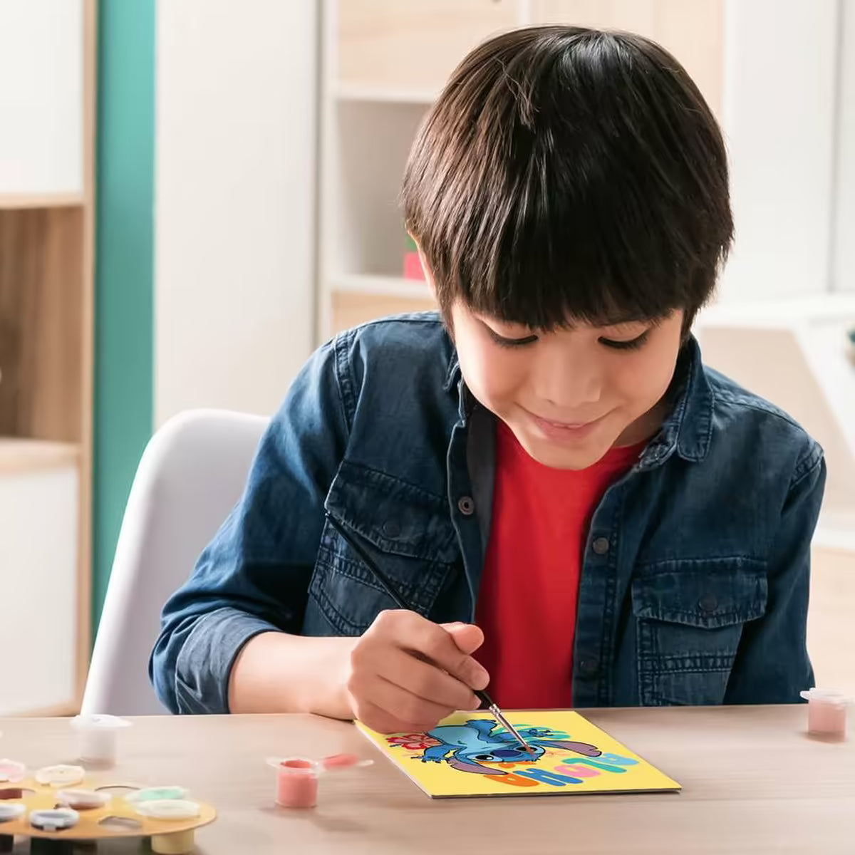 Jongen schildert Disney Stitch CreArt Aloha van Ravensburger, educatief knutsel idee en creatieve activiteit voor kinderen.