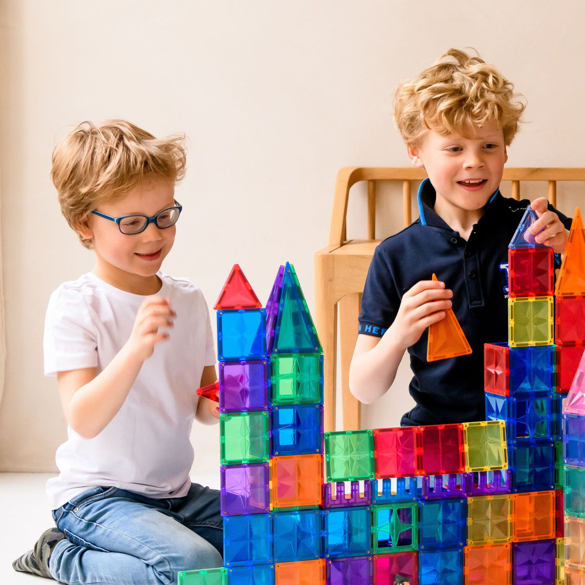 Twee jongens bouwen met magneet speelgoed Coblo, kleurrijke magnetische torens en constructies maken