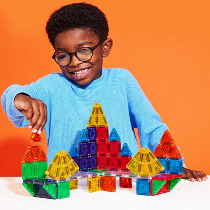 Een jongen bouwt een toren met de magnetic Magna Tiles deluxe microMAGS set van 70 magnetische bouwstenen in diverse kleuren.
