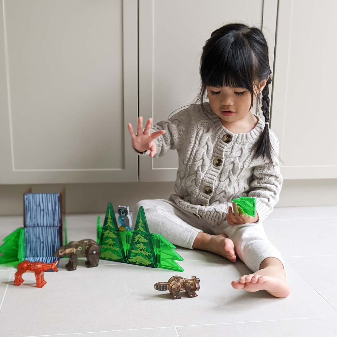 Kind bouwt met magnetic magna tiles Forest Animals magnetisch speelgoed en bosdieren thuis