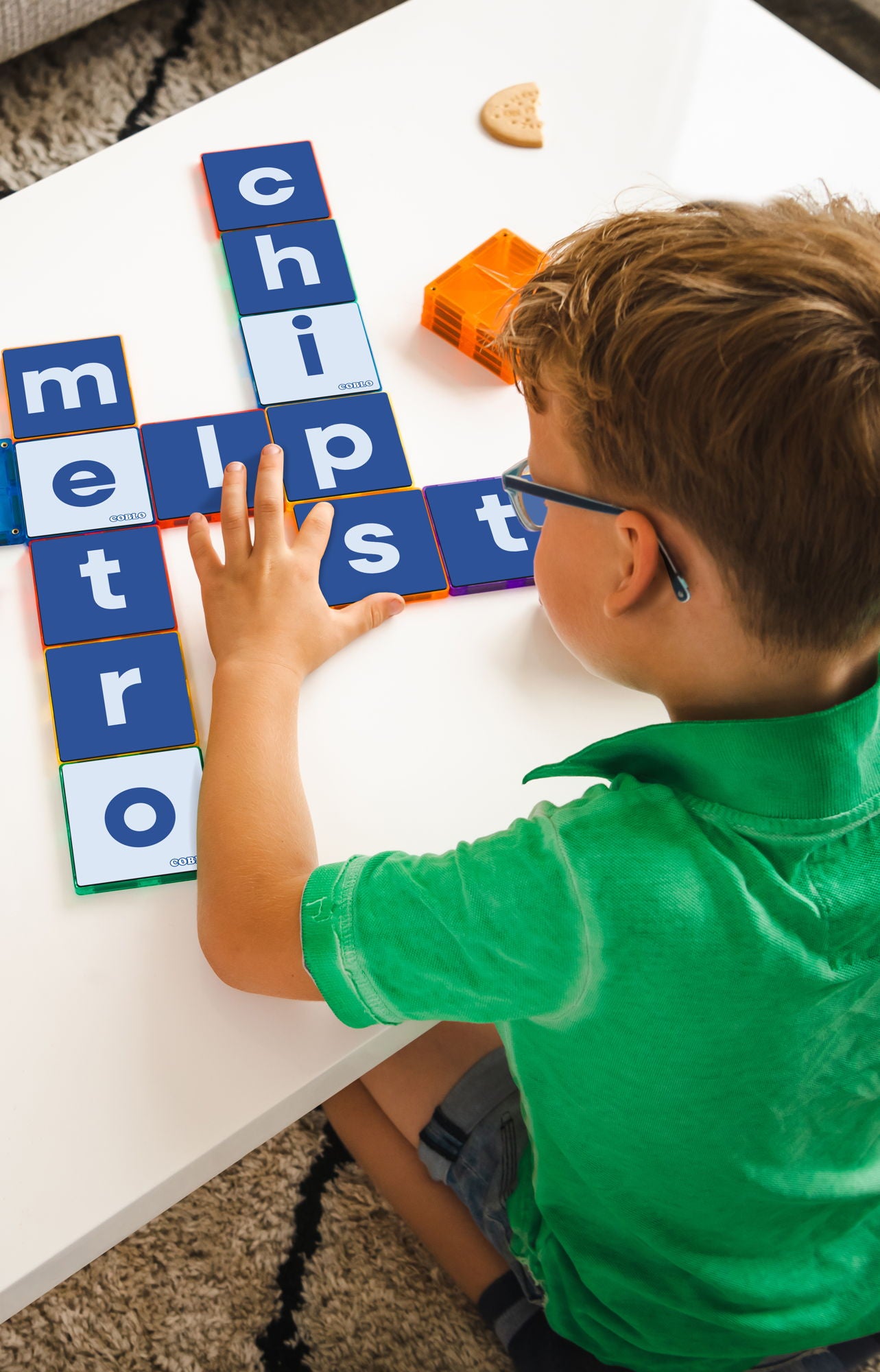 Kind speelt met Coblo Magneet Toppers Letters - bovenaanzicht jongen legt woorden met magneet speelgoed