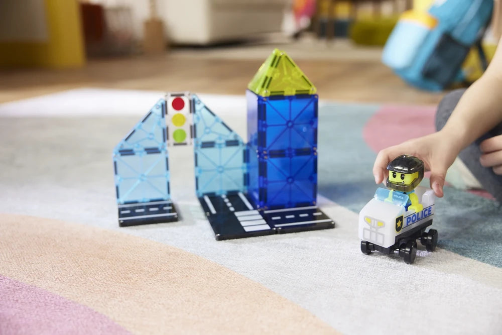 Magnetisch speelgoed van Magna Tiles Police Patrol met politiefiguur in voertuig en verkeerslicht, bespeeld door kind.