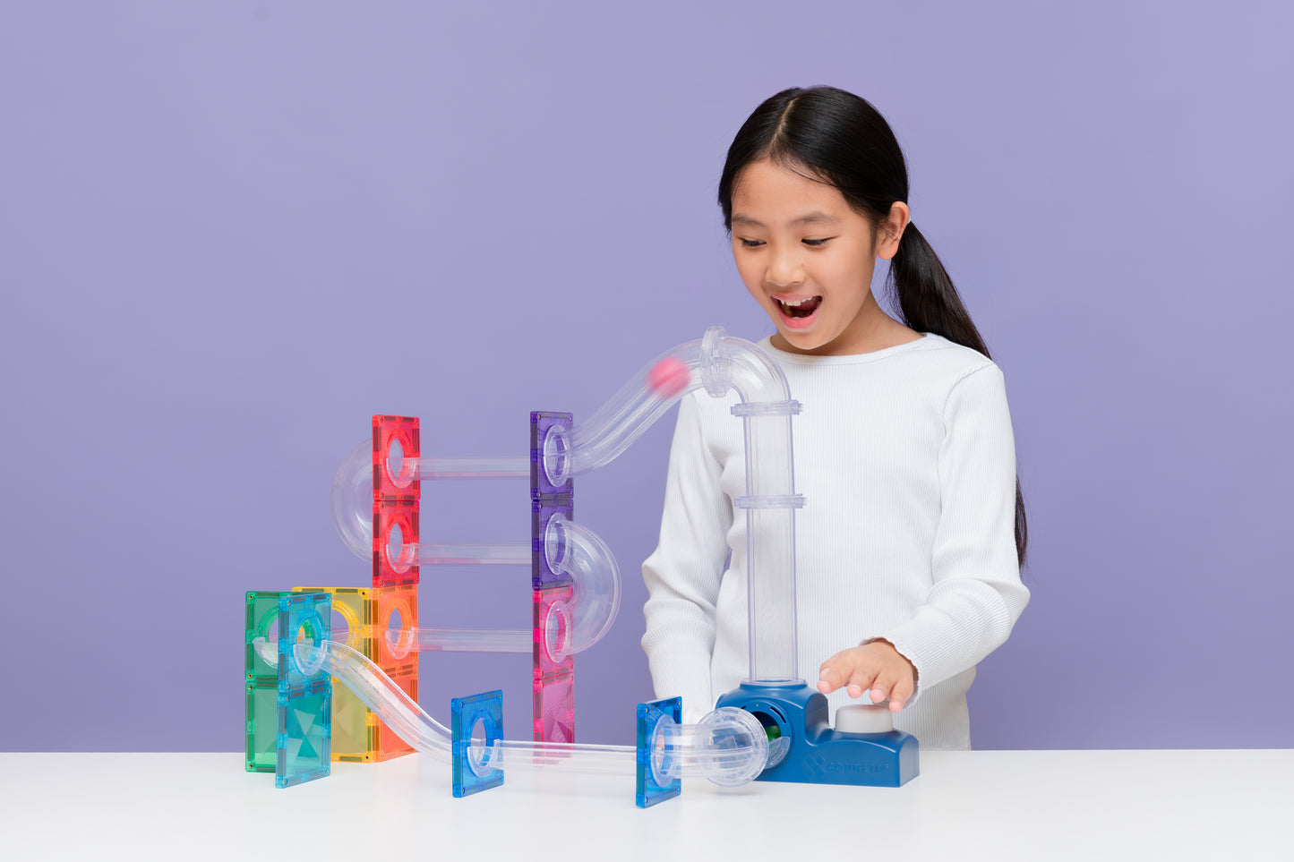 Kind speelt met Connetix ball run launcher pack, magnetische knikkerbaan met gekleurde tiles