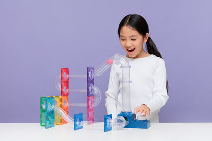 Kind speelt met Connetix ball run launcher pack, magnetische knikkerbaan met gekleurde tiles