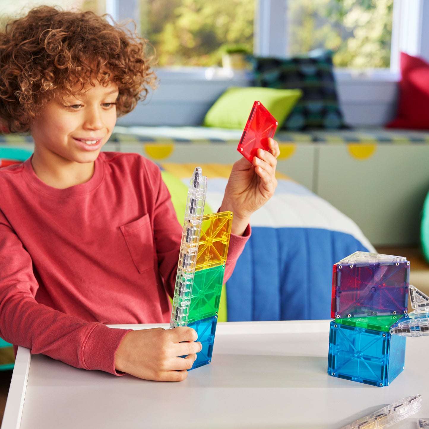 Kind speelt met magnetic magna tiles knikkerbaan magnetisch met kleurrijke rails en MicroMags